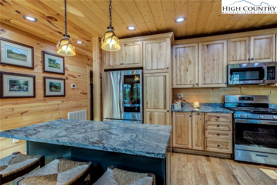 3460 South Center Church Road Thurmond, NC 28683 - Photo 20 of 50 a kitchen with kitchen island granite countertop wooden cabinets and a stove