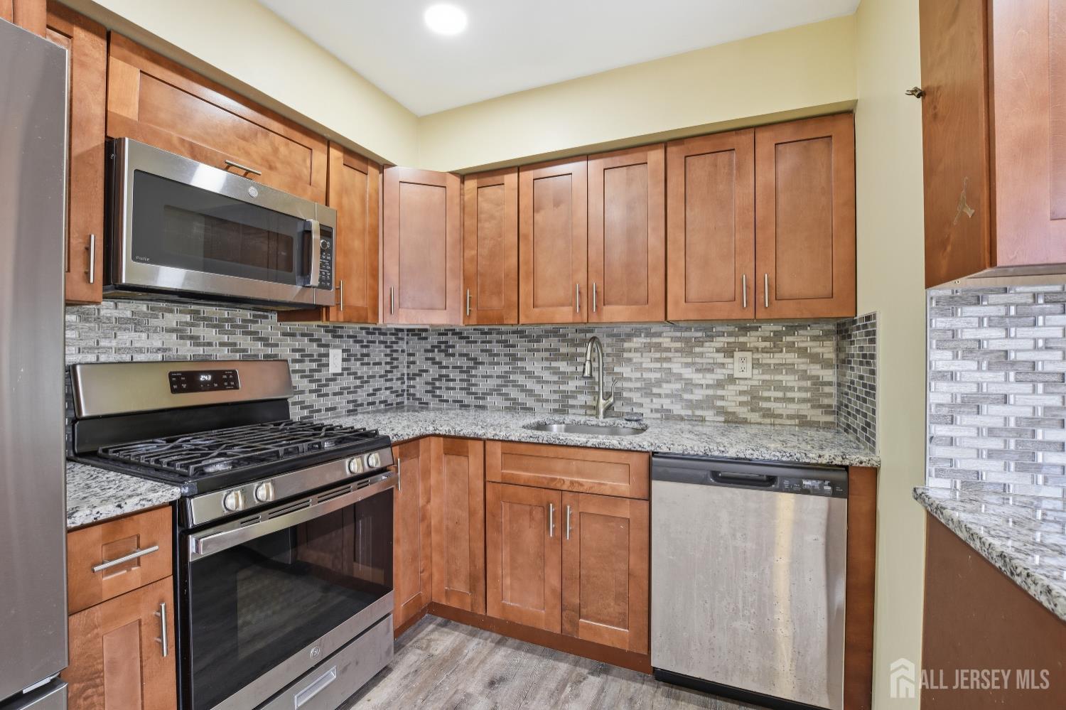 160 Evergreen Road, Unit 14A Edison, NJ 08837 - Photo 14 of 15 a kitchen with granite countertop a stove sink and microwave