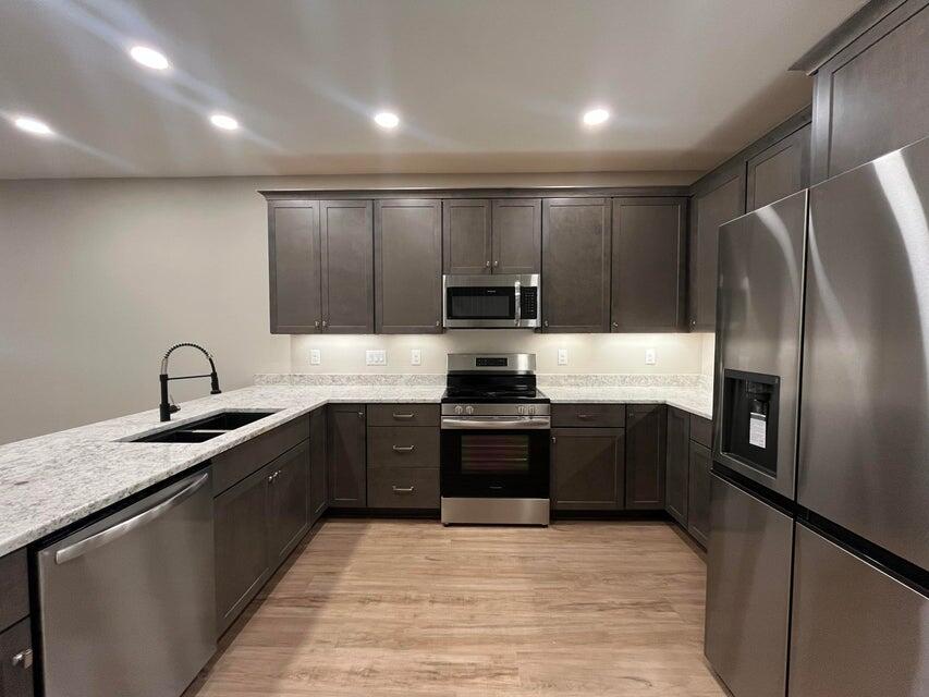 2879 Leahs Lane Navarre, FL 32566 - Photo 4 of 13 a large kitchen with stainless steel appliances granite countertop a sink a stove and refrigerator