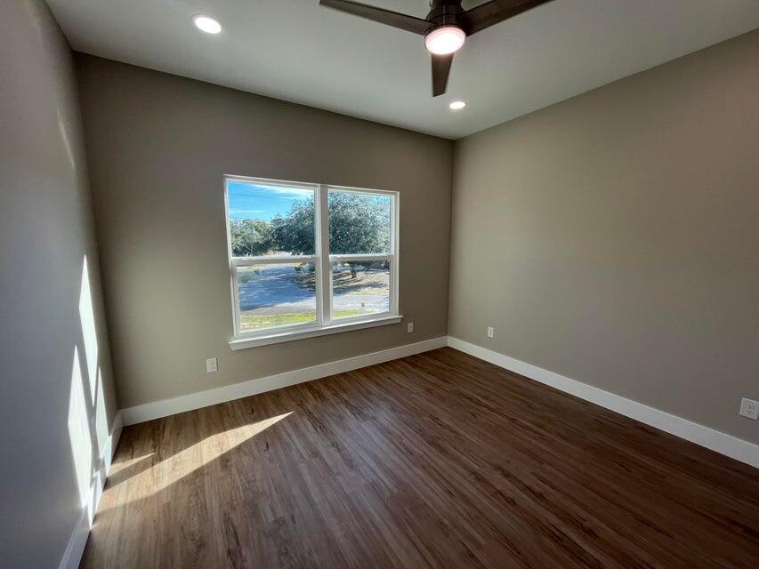 2879 Leahs Lane Navarre, FL 32566 - Photo 8 of 13 an empty room with wooden floor and windows
