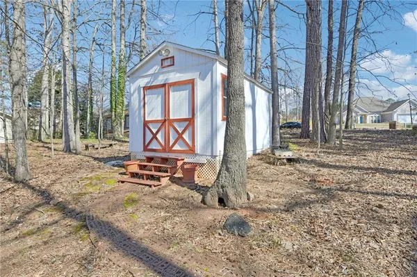 a backyard of a house with barbeque oven table and chairs