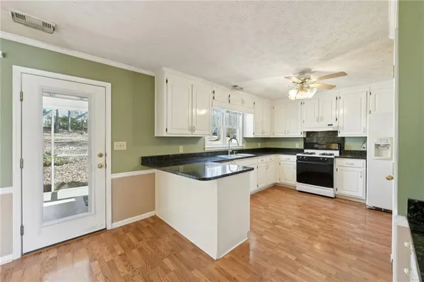 a large kitchen with cabinets a sink and a stove