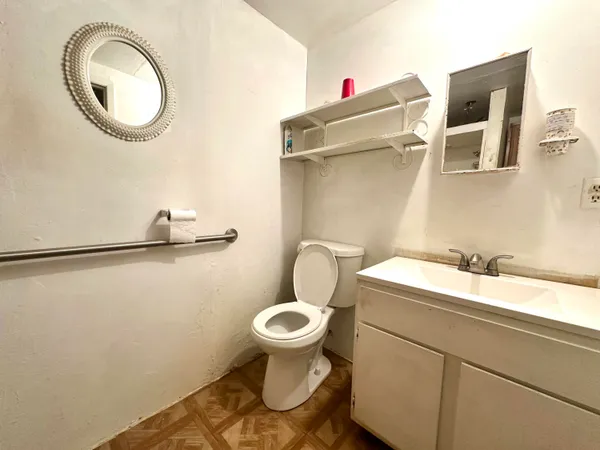 a bathroom with a granite countertop toilet and a sink