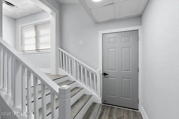 a view of staircase with railing and white walls