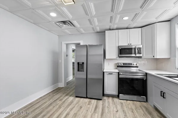 a kitchen with stainless steel appliances a stove microwave and refrigerator