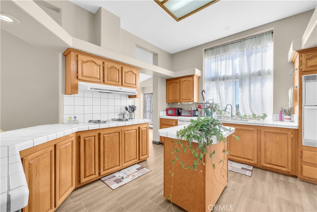 21720 Yucca Road Perris, CA 92570 - Photo 10 of 58 a kitchen with stainless steel appliances granite countertop white cabinets a sink dishwasher and a stove with wooden floor