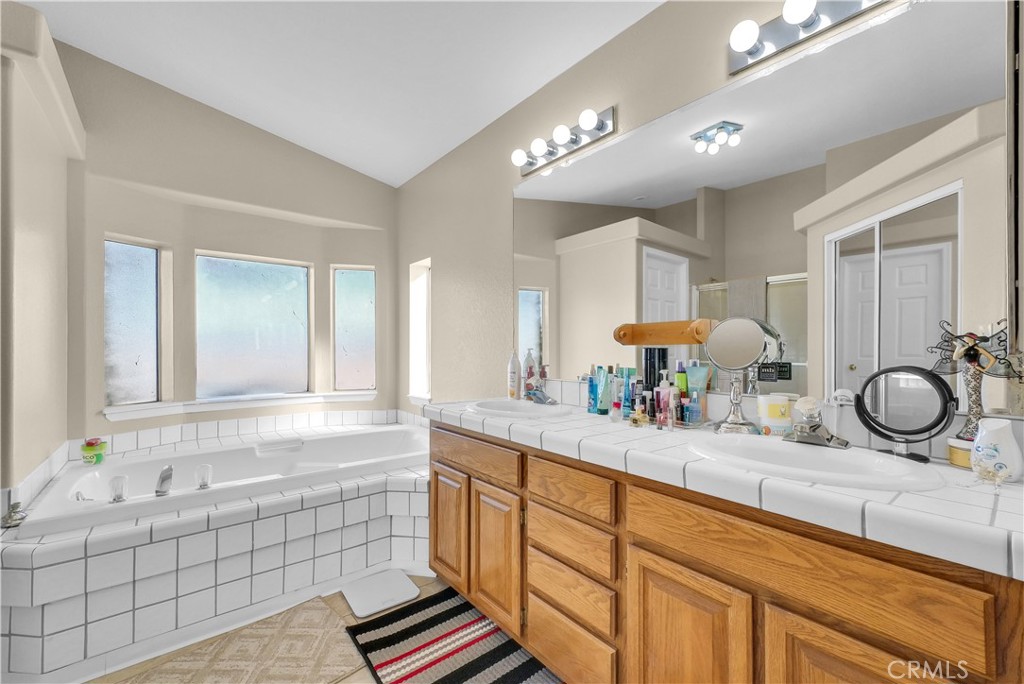 21720 Yucca Road Perris, CA 92570 - Photo 18 of 58 a bathroom with a granite countertop sink a mirror and a bath tub
