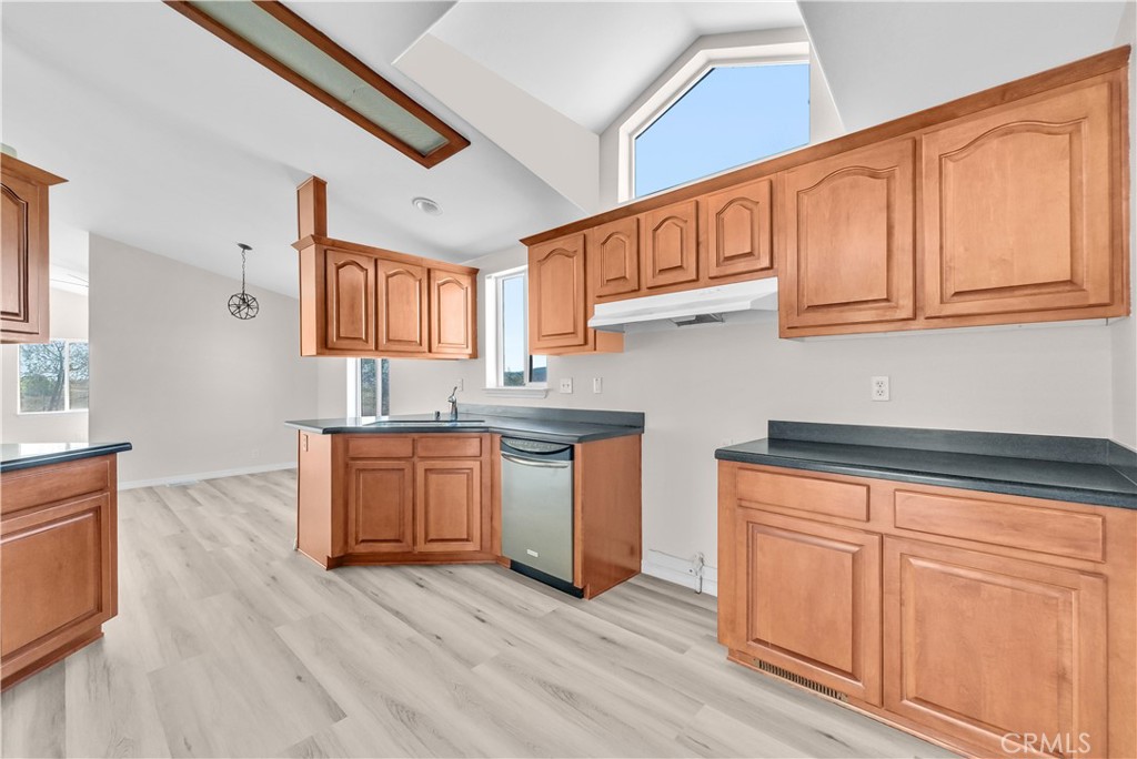 21720 Yucca Road Perris, CA 92570 - Photo 30 of 58 a kitchen with granite countertop wooden cabinets a sink and dishwasher