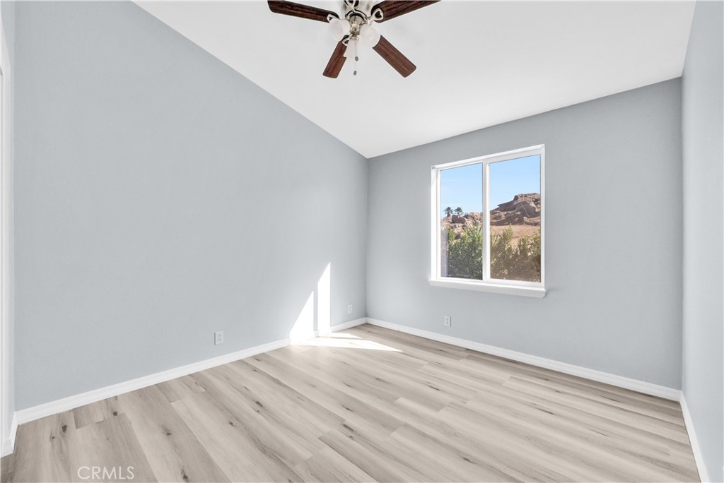 21720 Yucca Road Perris, CA 92570 - Photo 34 of 58 an empty room with wooden floor chandelier fan and windows