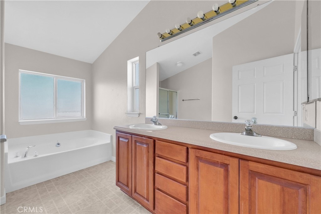 21720 Yucca Road Perris, CA 92570 - Photo 40 of 58 a bathroom with a granite countertop sink mirror and a bathtub