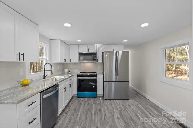 a kitchen with a sink a refrigerator and wooden floors