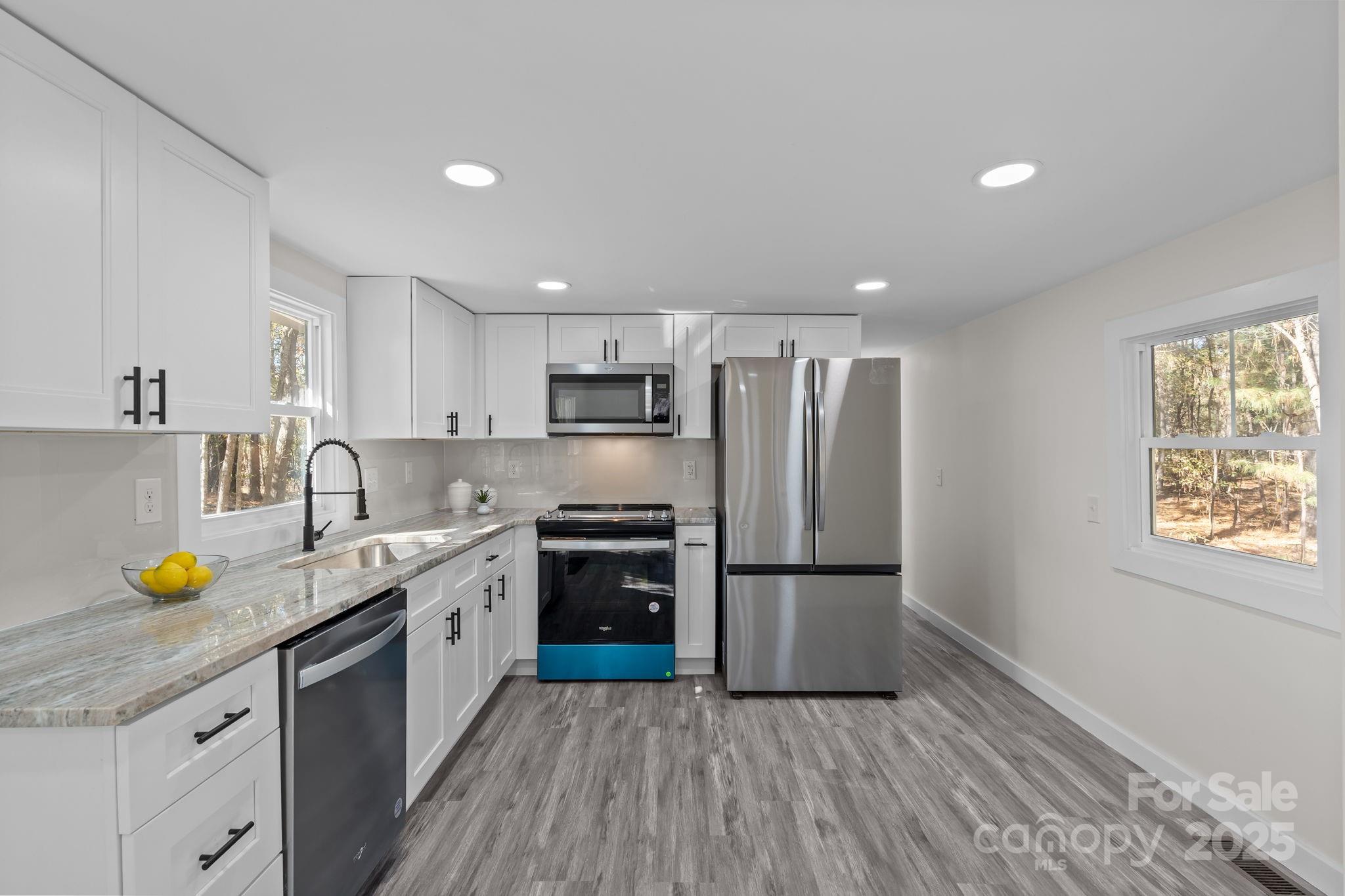2627 McCallum Road Candor, NC 27229 - Photo 14 of 41 a kitchen with a sink a refrigerator and wooden floors