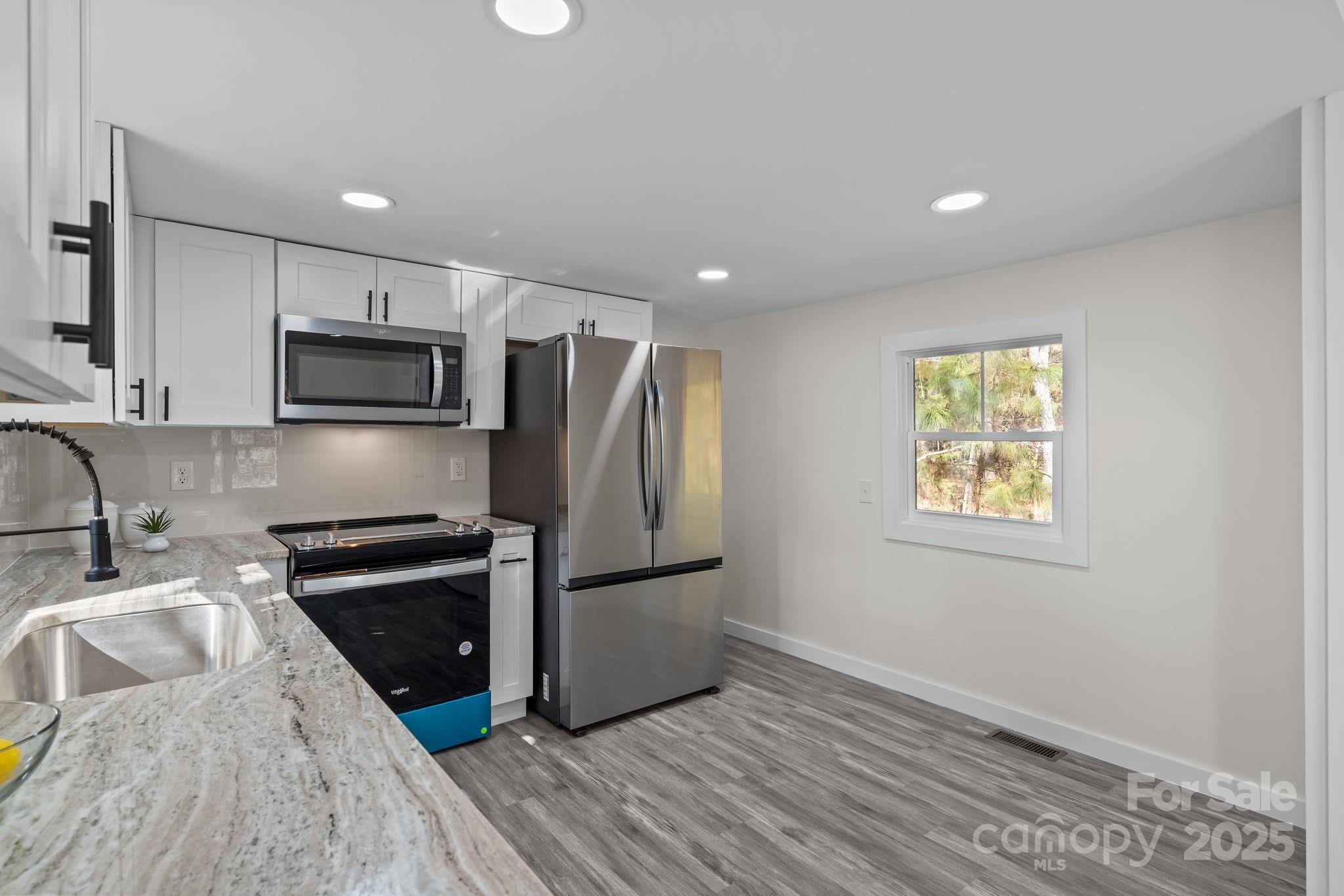 2627 McCallum Road Candor, NC 27229 - Photo 16 of 41 a kitchen with granite countertop a refrigerator stove and sink