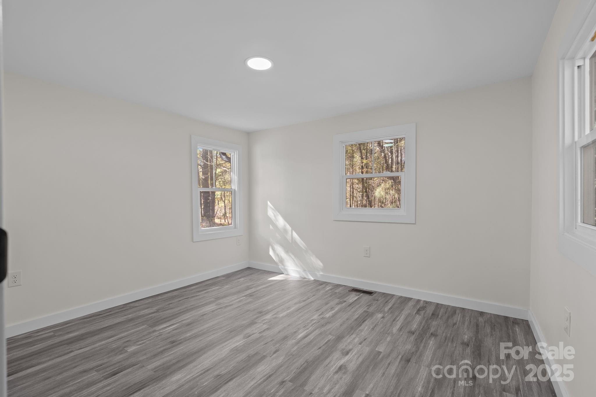 2627 McCallum Road Candor, NC 27229 - Photo 28 of 41 an empty room with wooden floor and windows