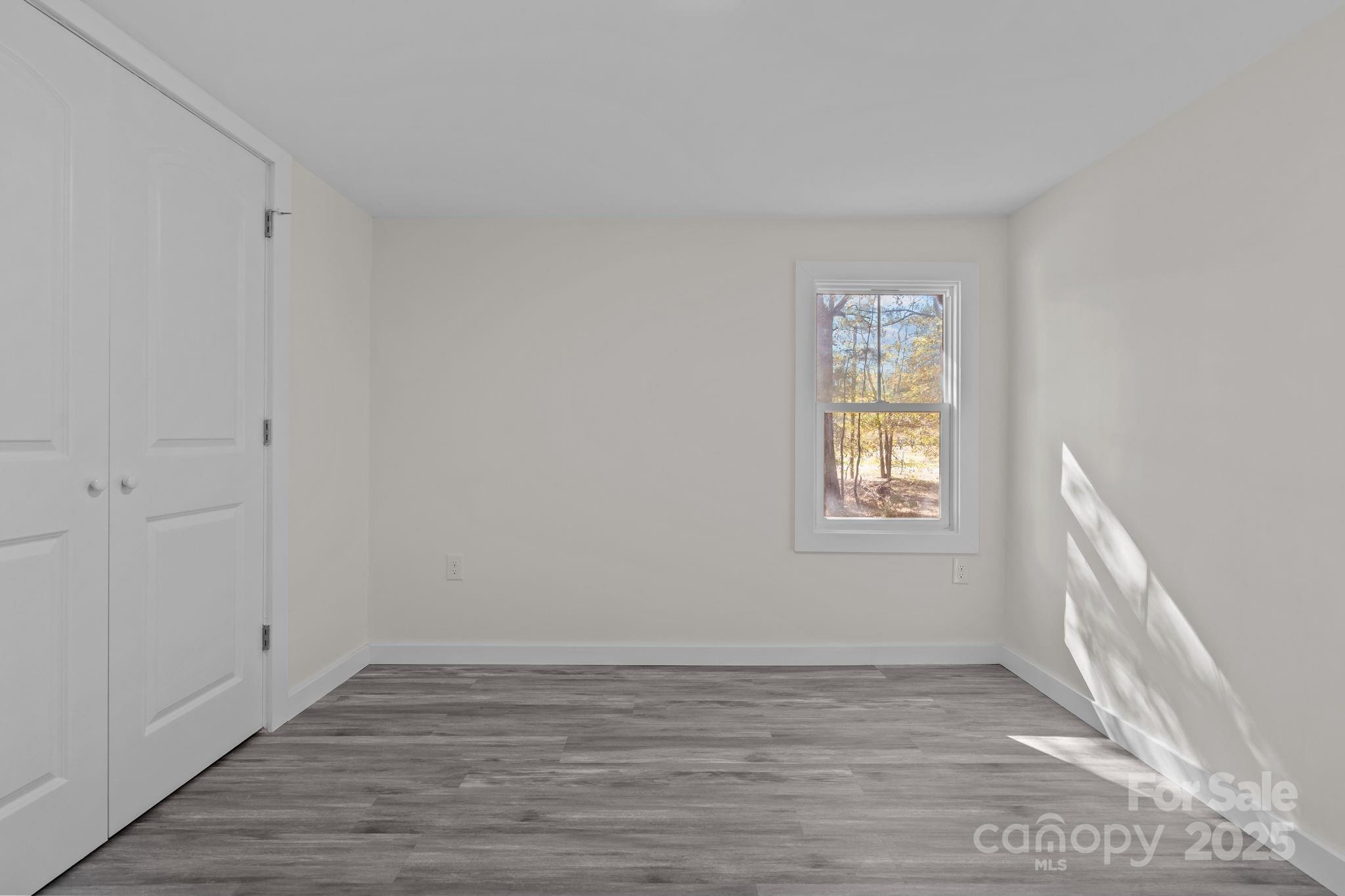2627 McCallum Road Candor, NC 27229 - Photo 30 of 41 a view of an empty room with wooden floor and a window