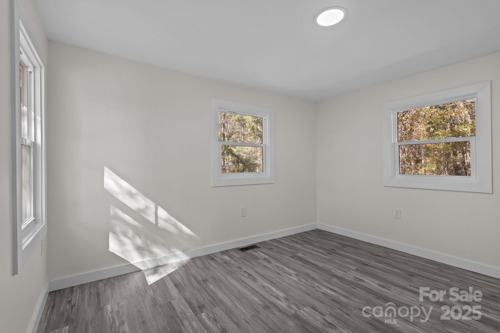 2627 McCallum Road Candor, NC 27229 - Photo 32 of 41 an empty room with wooden floor and windows