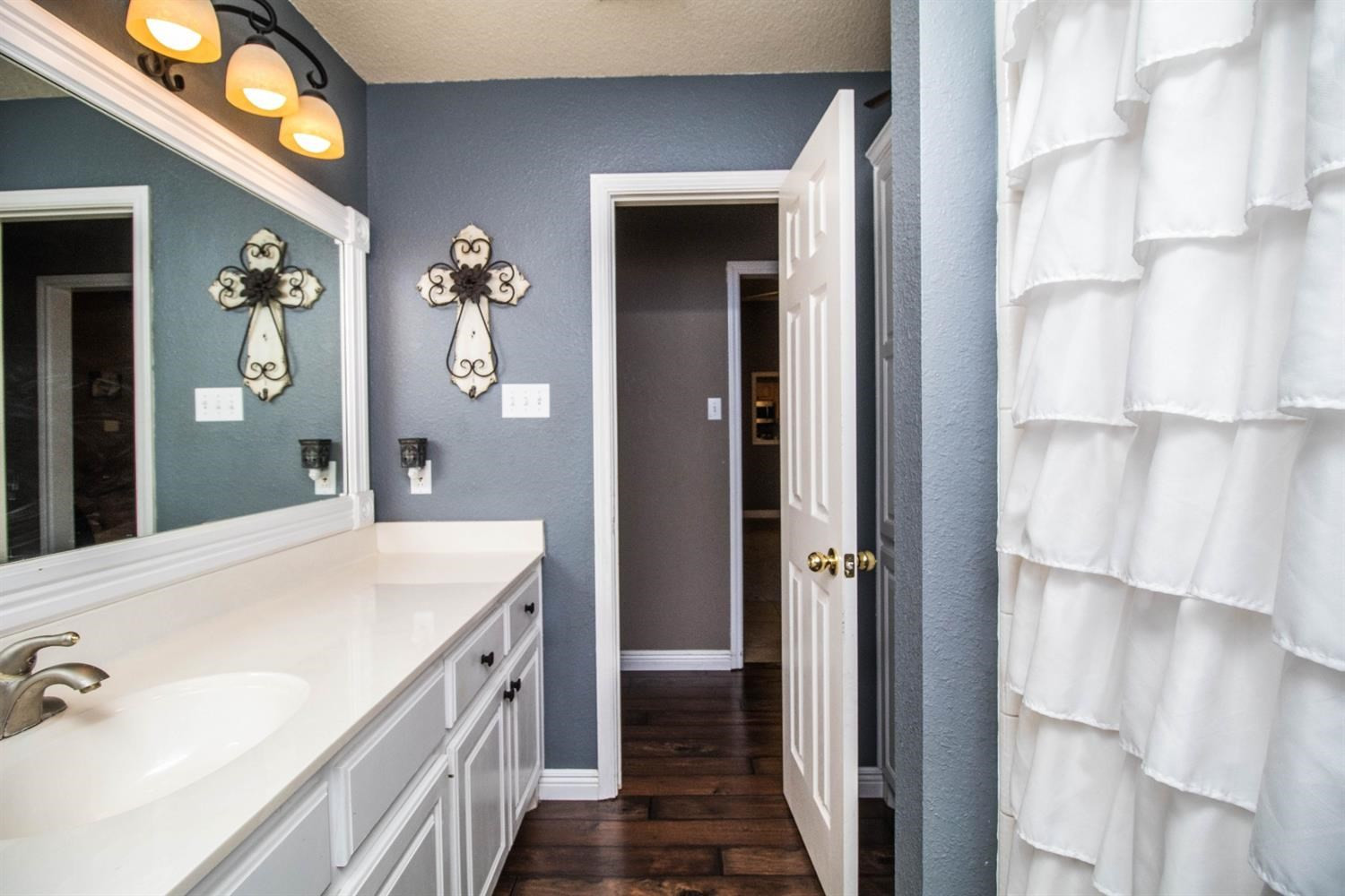5821 89th Street Lubbock, TX 79424 - Photo 13 of 19 a bathroom with a double vanity sink and mirror with shower