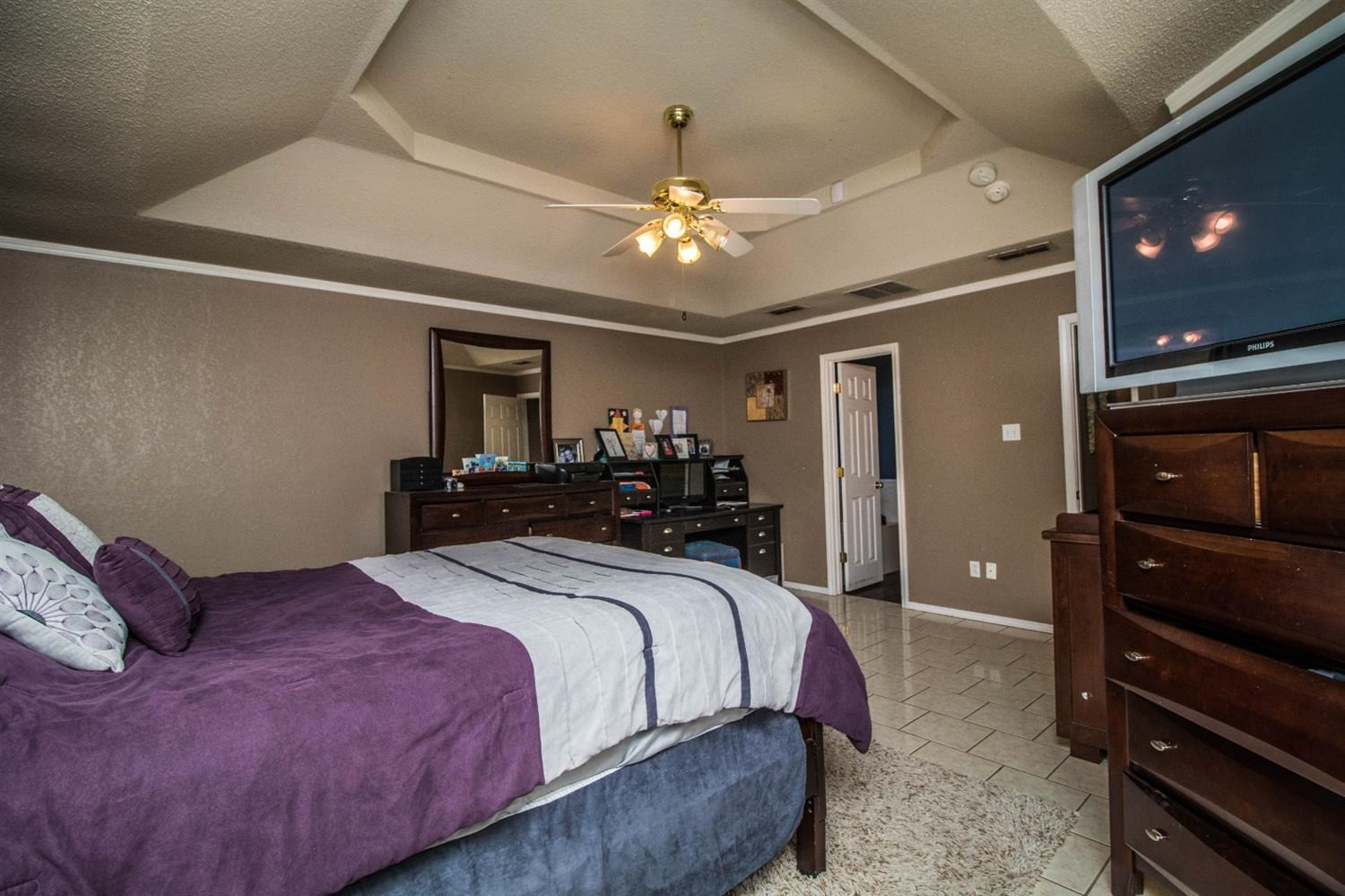 5821 89th Street Lubbock, TX 79424 - Photo 16 of 19 a bedroom with a bed and a chandelier