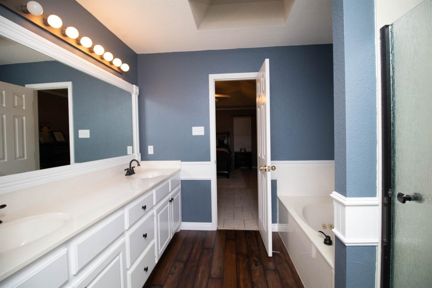 5821 89th Street Lubbock, TX 79424 - Photo 17 of 19 a spacious bathroom with a double vanity sink and a mirror