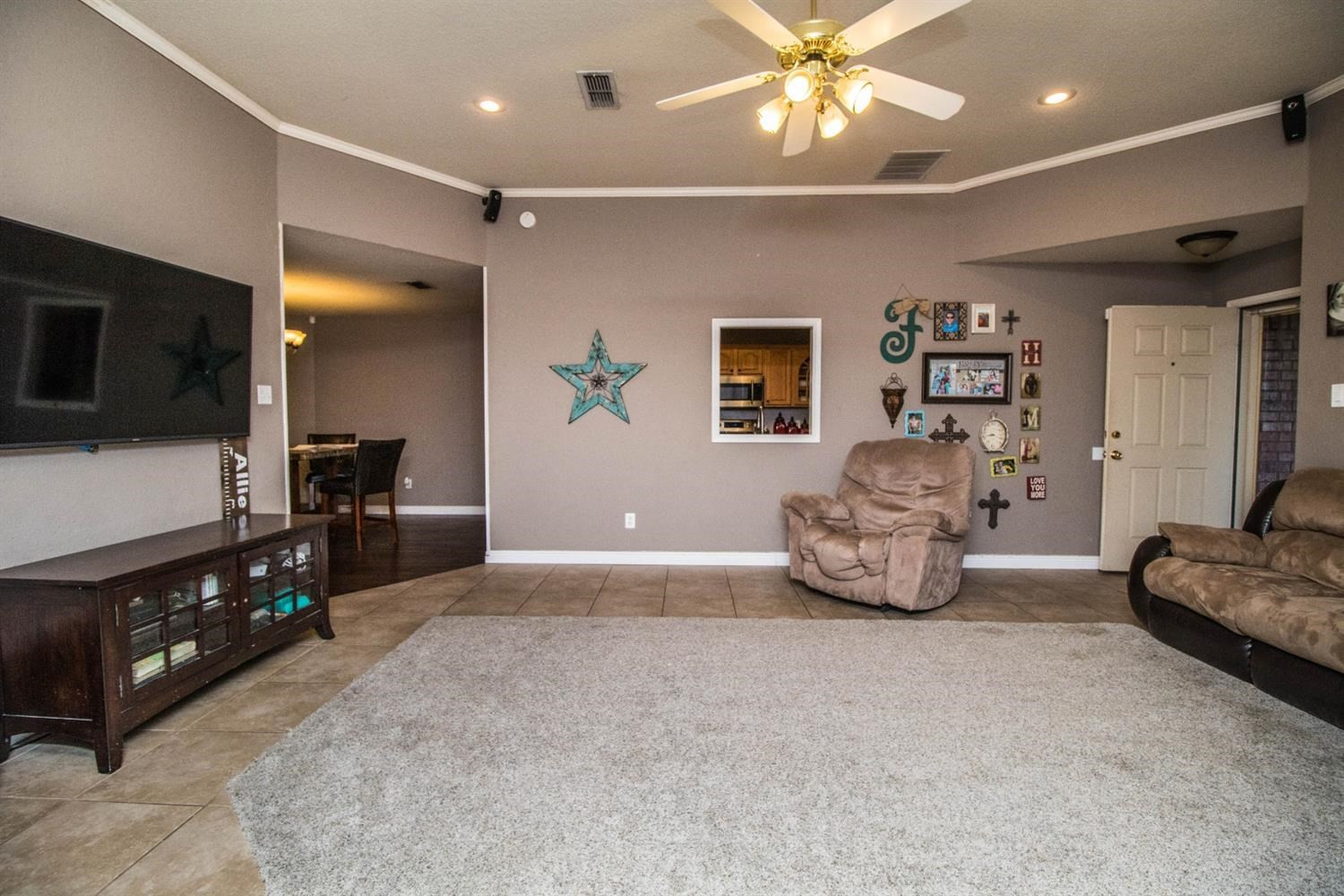 5821 89th Street Lubbock, TX 79424 - Photo 4 of 19 a spacious bedroom with a bed and a flat tv screen on dresser