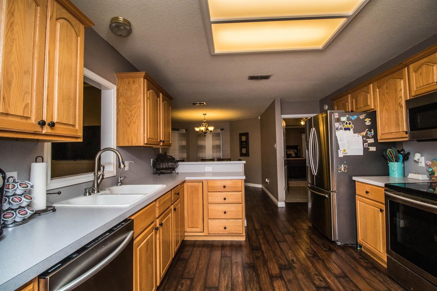 5821 89th Street Lubbock, TX 79424 - Photo 9 of 19 a kitchen with stainless steel appliances granite countertop a sink a stove cabinets counter space and wooden floor
