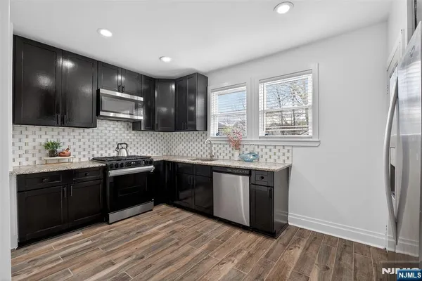 a large kitchen with stainless steel appliances granite countertop a stove a sink and a microwave