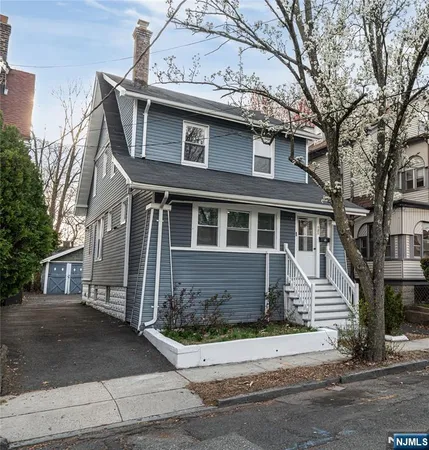 a front view of a house with a tree