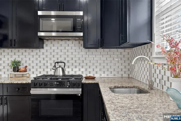a kitchen with a sink a stove and cabinets