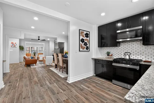 a living room with furniture a flat screen tv and kitchen view