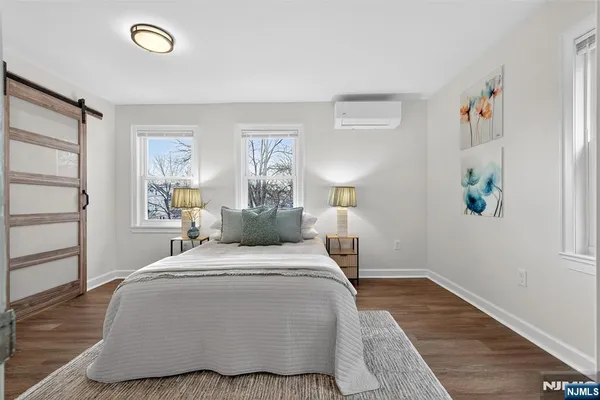 a bedroom with a bed and painting on the wall