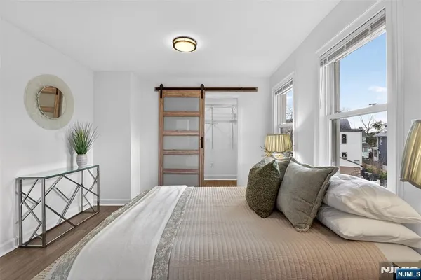 a bedroom with a bed and painting on the wall