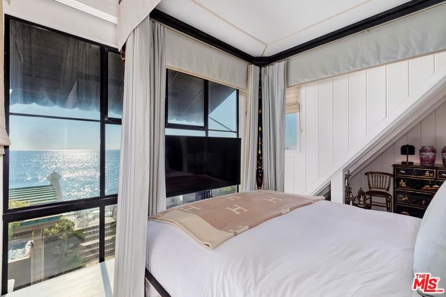 a bedroom with a bed and a large window