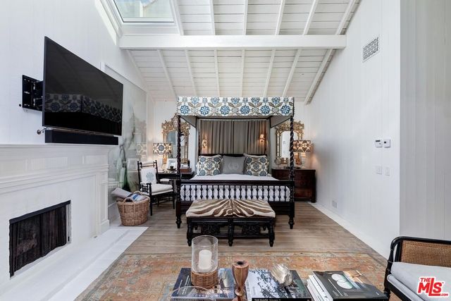 a bedroom with furniture a fireplace and a flat tv screen