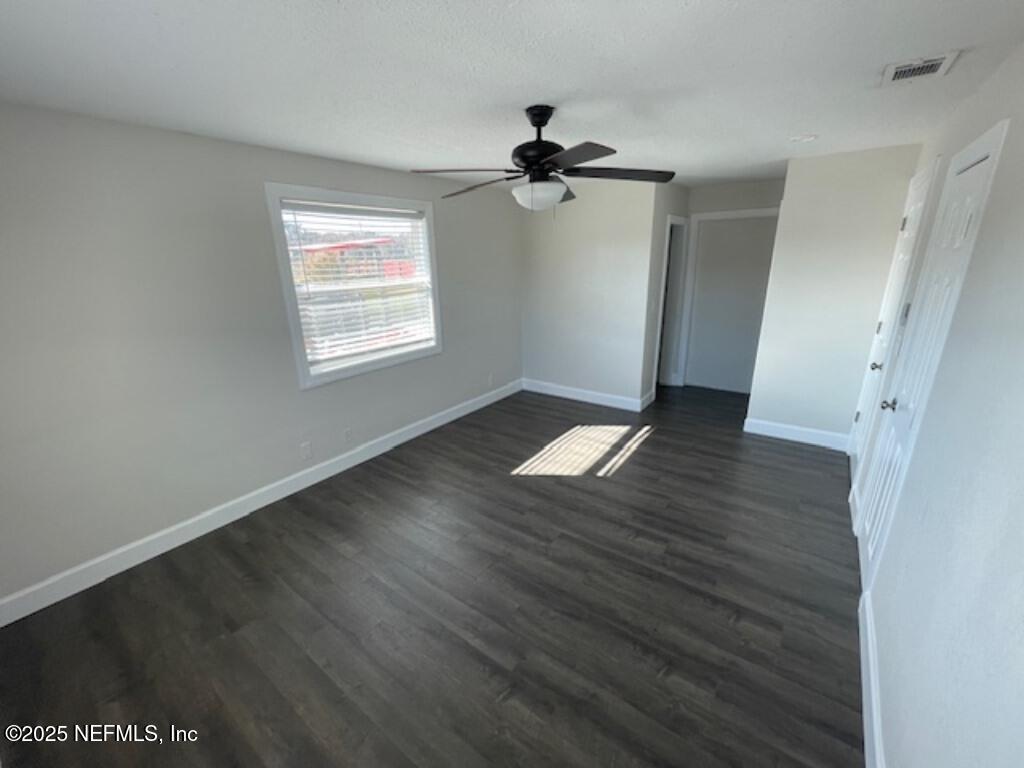 14014 Lem Turner Road Jacksonville, FL 32218 - Photo 21 of 25 an empty room with wooden floor cabinet and windows