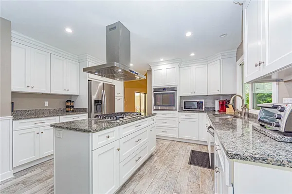 a kitchen with stainless steel appliances granite countertop a sink stove and cabinets