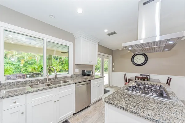 a bathroom with a granite countertop sink and a window