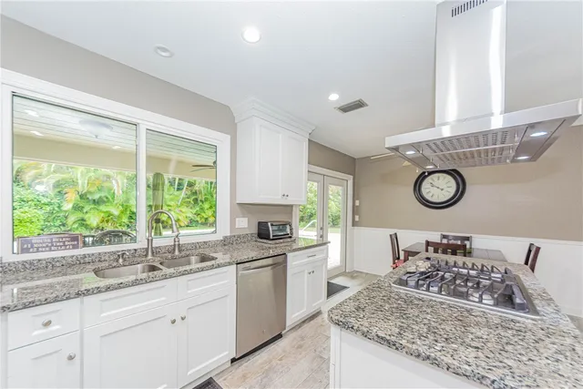 a bathroom with a granite countertop sink and a window