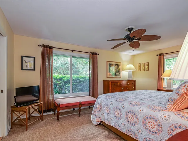 a bedroom with a bed and a chandelier next to a window