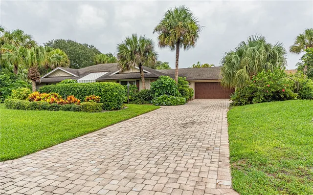 a front view of a house with a yard and potted plants