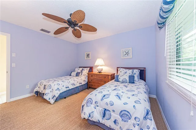 a bedroom with two beds and a chandelier