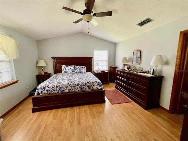 a bedroom with a bed and wooden floor
