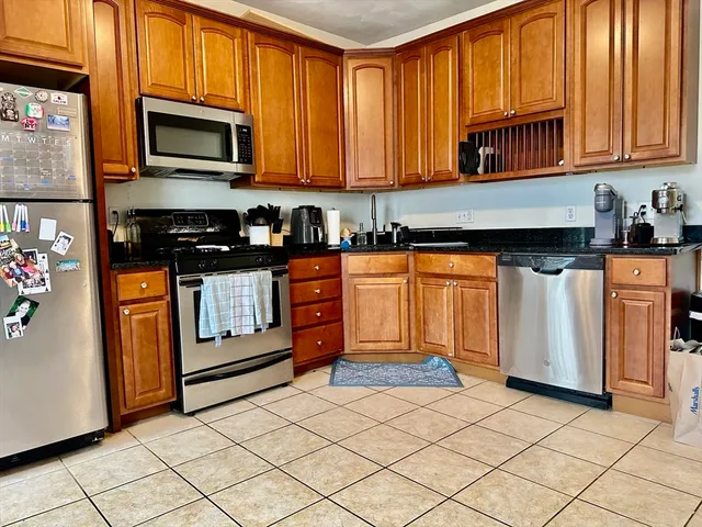 a kitchen with stainless steel appliances granite countertop a stove a sink and a microwave
