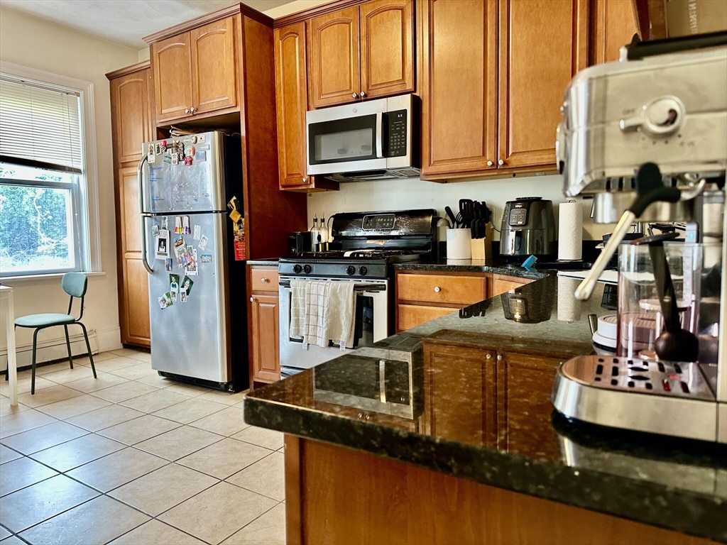 12-14 Marcella Street, Unit 2 Cambridge, MA 02141 - Photo 16 of 23 a kitchen with stainless steel appliances granite countertop a refrigerator and a stove top oven