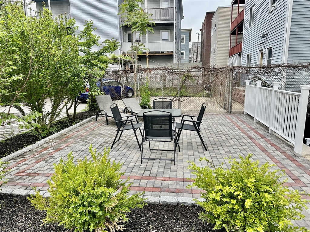 12-14 Marcella Street, Unit 2 Cambridge, MA 02141 - Photo 20 of 23 a view of a patio with table and chairs potted plants and large tree