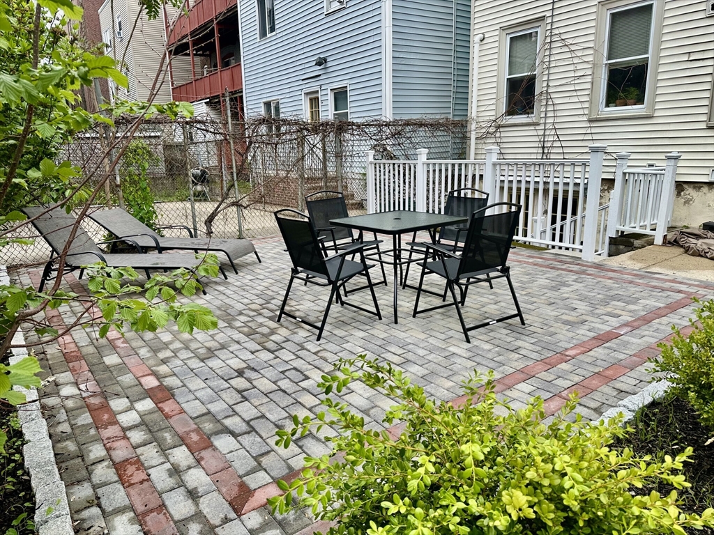 12-14 Marcella Street, Unit 2 Cambridge, MA 02141 - Photo 21 of 23 a view of a chairs and table in backyard of the house