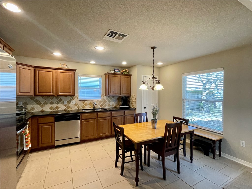 103 Sandollar Circle Fulton, TX 78382 - Photo 8 of 25 a kitchen with granite countertop a stove a sink a dining table and chairs