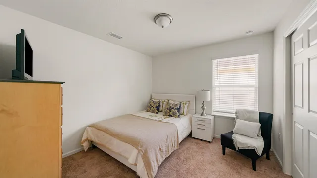 a bedroom with a bed and a chair