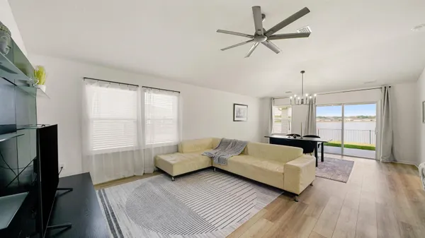 a living room with furniture ceiling fan and a window