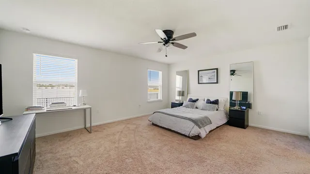 a spacious bedroom with a bed and window