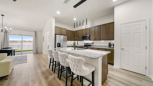 a kitchen with kitchen island granite countertop a center island a sink stainless steel appliances and cabinets